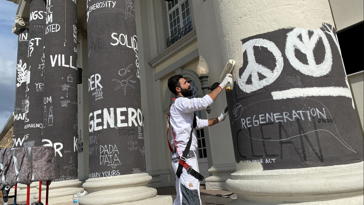 Am Tag nach dem Ende der documenta fifteen werden die Säulen des Fridericianums in Kassel übermalt. - Foto: Uwe Zucchi/dpa