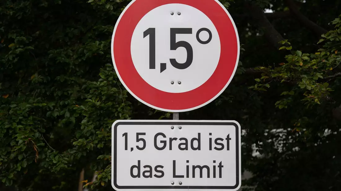 Mit diesen Schildern machen Klima-Aktivisten auf das Ziel des Pariser Klimaabkommens aufmerksam. - Bild: Paul Zinken/dpa