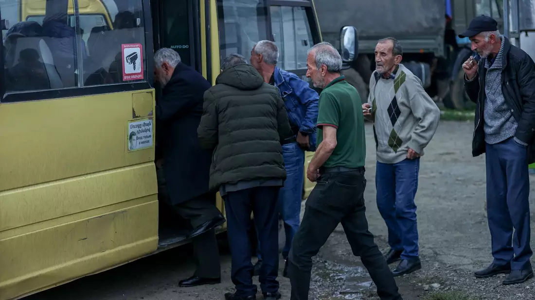 Ethnisch-armenische Männer steigen im Oktober in einen Bus nach Goris in Armenien ein. - Bild: Aziz Karimov/AP/dpa
