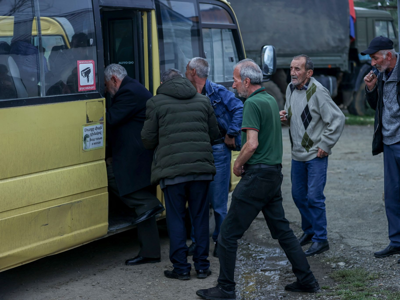 Ethnisch-armenische Männer steigen im Oktober in einen Bus nach Goris in Armenien ein. - Foto: Aziz Karimov/AP/dpa