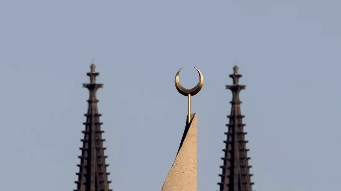 Der Halbmond auf einer Moschee ist zwischen den Türmen des Kölner Doms zu sehen. Der Auftritt eines hochrangigen afghanischen Taliban-Funktionärs in einer Kölner Moschee löst harsche Kritik aus. - Bild: Rolf Vennenbernd/dpa