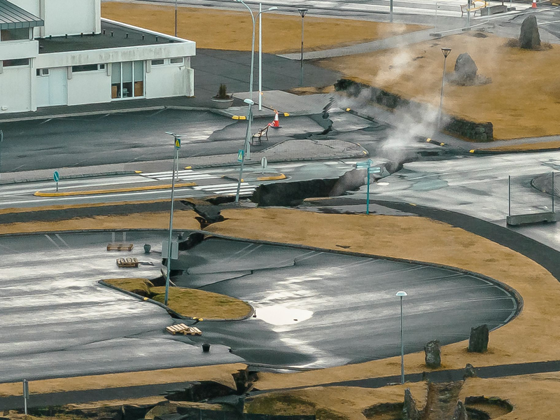 In der isländsichen Stadt Grindavik steigt Rauch aus Rissen im Boden. - Foto: Bjorn Steinbekk/AP/dpa