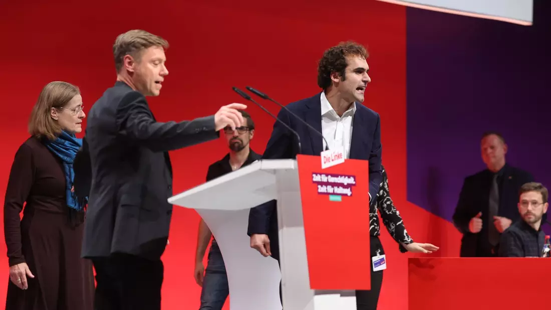 Eklat auf offener Bühne: Bijan Tavassoli (r) nutzte seine Bewerbungsrede für eine Beschimpfung der Linken und eine Lobrede auf Sahra Wagenknecht - und erklärte zum Abschluss seiner Rede seinen Parteiaustritt. - Bild: Karl-Josef Hildenbrand/dpa
