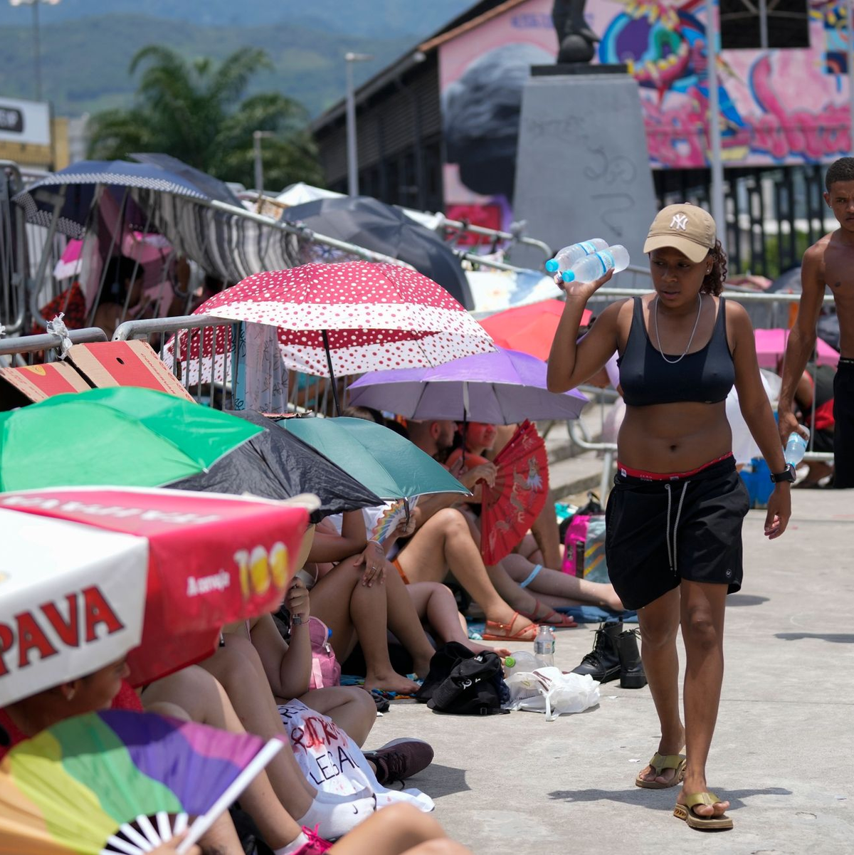 Straßenhändler verkaufen vor dem Konzert von Taylor Swift vor dem Olympiastadion in Rio Wasserflaschen. - Foto: Silvia Izquierdo/AP/dpa
