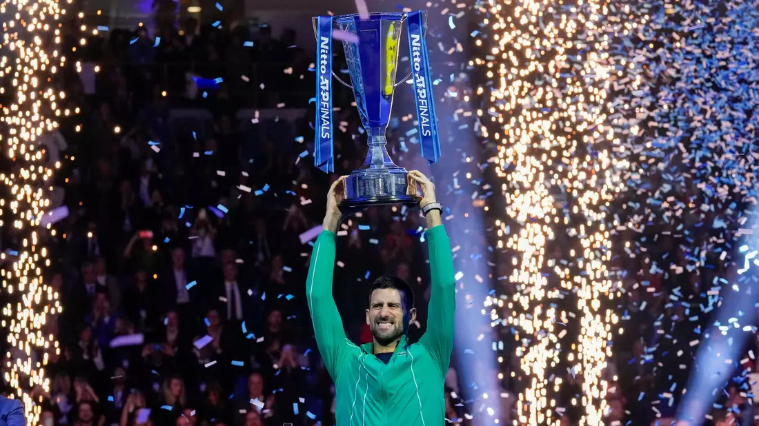 Novak Djokovic jubelt mit seiner Trophäe nach seinem Sieg. - Bild: Antonio Calanni/AP/dpa