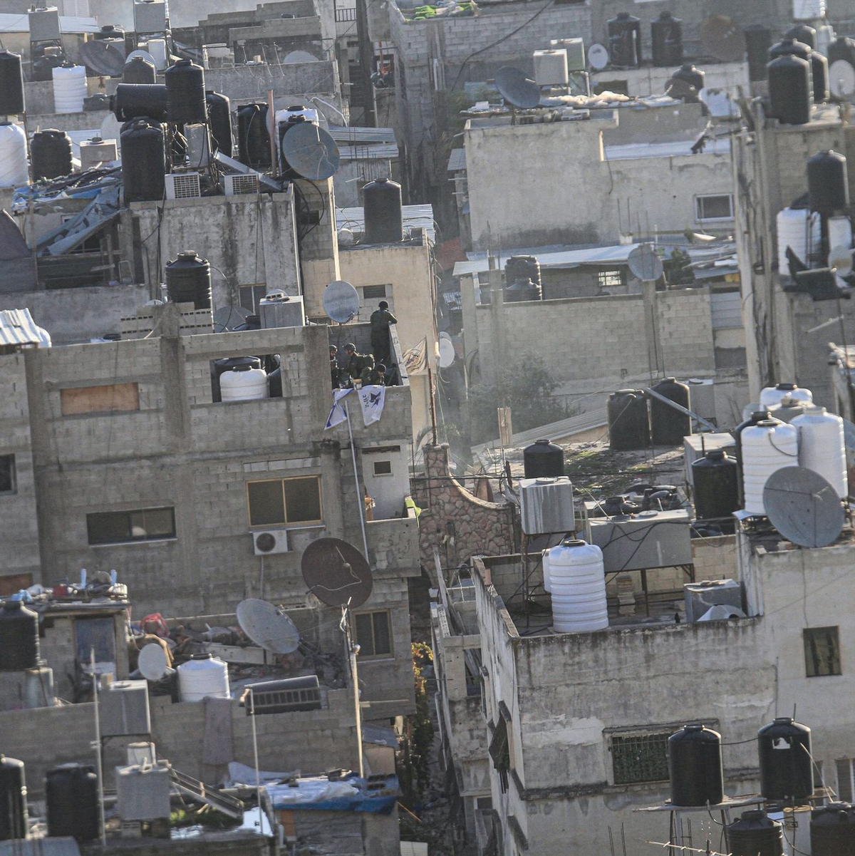 Israelische Soldaten platzieren die israelische Fahne auf einem Balkon im Flüchtlingslager Balata im Westjordanland. - Foto: Nasser Ishtayeh/SOPA Images via ZUMA Press Wire/dpa