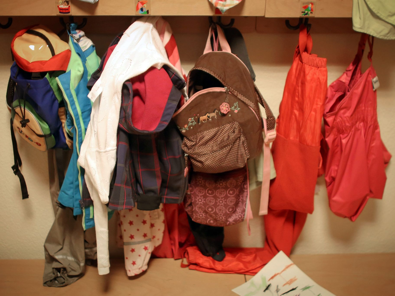 Jacken und Rucksäcke von Kindern in der Garderobe einer Betriebskita. - Foto: Fredrik Von Erichsen/dpa