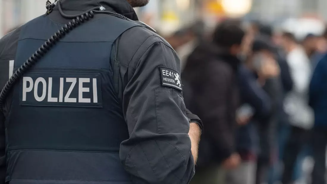 Ein Polizist im Einsatz während einer Razzia: Razzien gab es laut dem Bericht unter anderem in München und Nürnberg. - Bild: Swen Pförtner/dpa