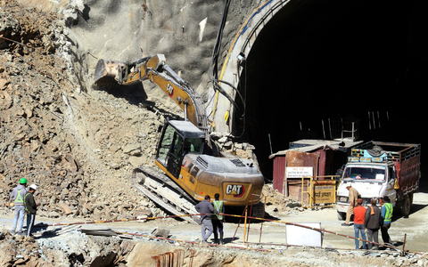 Retter beraten sich vor dem teilweise eingestürzten Straßentunnel im indischen Silkyara. - Foto: ---/AP/dpa