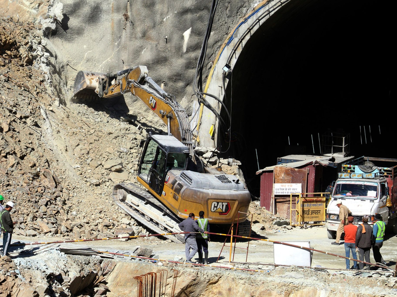 Retter beraten sich vor dem teilweise eingestürzten Straßentunnel im indischen Silkyara. - Foto: ---/AP/dpa
