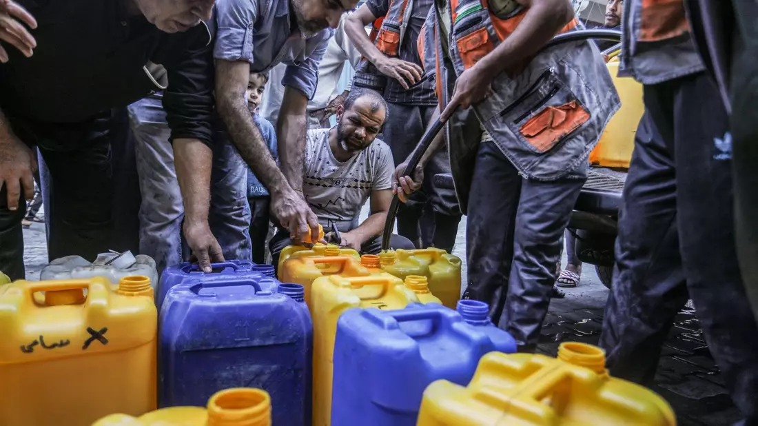 Palästinenser stehen Schlange, um Wasser zu bekommen. - Bild: Abed Rahim Khatib/dpa