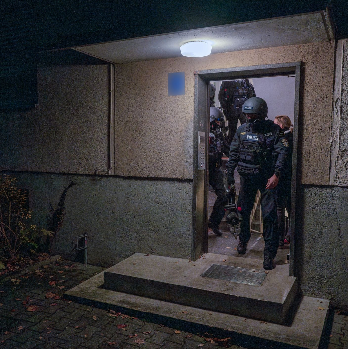 Die Polizei durchsucht ein Objekt in München. - Foto: Peter Kneffel/dpa