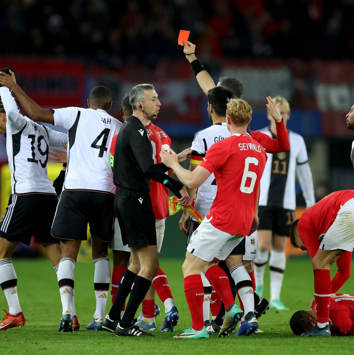 Deutschlands Leroy Sané (l) sah nach einer Tätlichkeit an Österreichs Phillipp Mwene die Rote Karte. - Foto: Christian Charisius/dpa