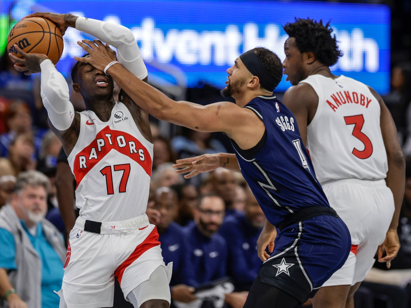 Orlandos Jalen Suggs (M) foult Torontos Dennis Schröder (17). - Foto: Kevin Kolczynski/AP/dpa