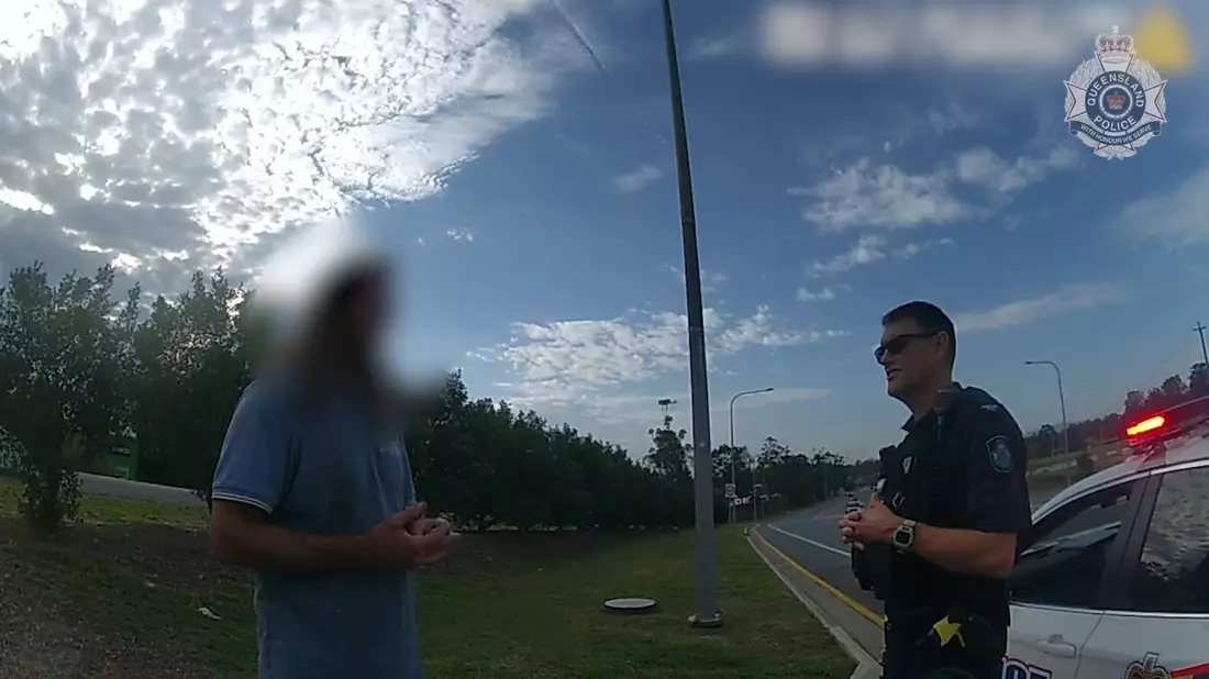 Ein Videostandbild der Polizei Queensland zeigt den Mann im Gespräch mit einem Beamten. - Bild: Queensland Police/QUEENSLAND POLICE/AP/dpa
