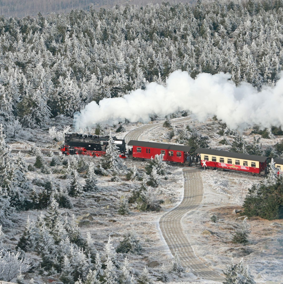 Idyllisch: Ein Zug der Harzer Schmalspurbahnen fährt durch den mit Raureif bedeckten Brockenwald. - Foto: Matthias Bein/dpa