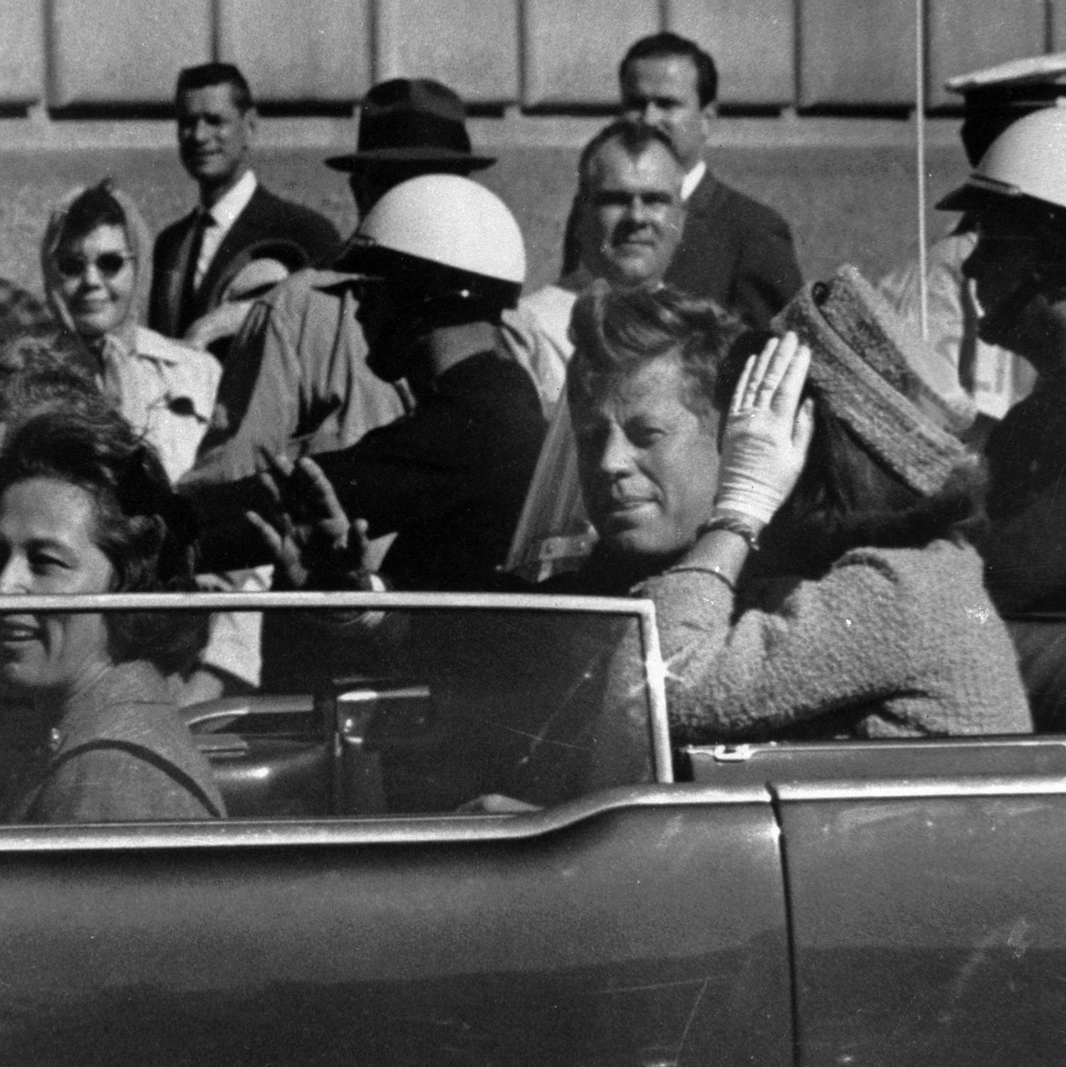 Kurz vor seiner Ermordung sitzt der damalige US-Präsident John F. Kennedy am 22.11.1963 in Dallas zusammen mit seiner Frau Jacqueline Kennedy (r) sowie dem dem Gouverneur von Texas, John Connally, und desen Frau Nellie Connally in einer offenen Limousine. - Foto: ---/AP/dpa