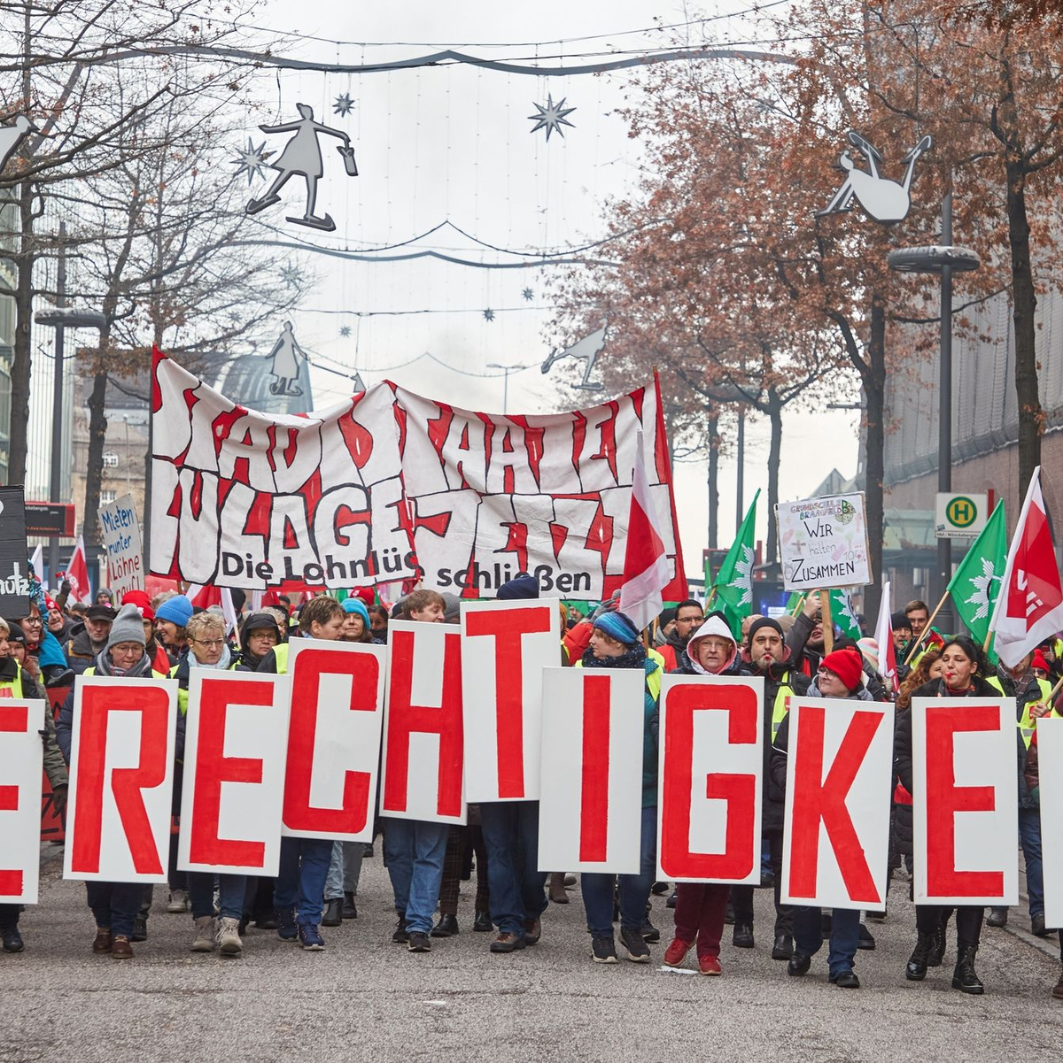 «Gerechtigkeit» - Teilnehmer ziehen beim «Stadtstaatenstreik» durch die Hamburger Mönckebergstraße. - Foto: Georg Wendt/dpa