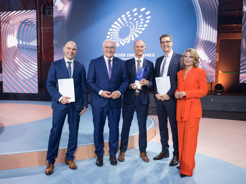 David M. Grodzki (l-r), Bundespräsident Frank-Walter Steinmeier, Stephan Biber, Michael Uder und Moderation Yve Fehring stehen nach der Verleihung des Deutschen Zukunftspreises 2023 zusammen. - Foto: Sebastian Christoph Gollnow/dpa