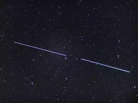 Zwei «Starlink»-Satelliten sind als Lichtstreifen am Nachthimmel zu sehen. - Foto: Patrick Pleul/dpa-Zentralbild/dpa