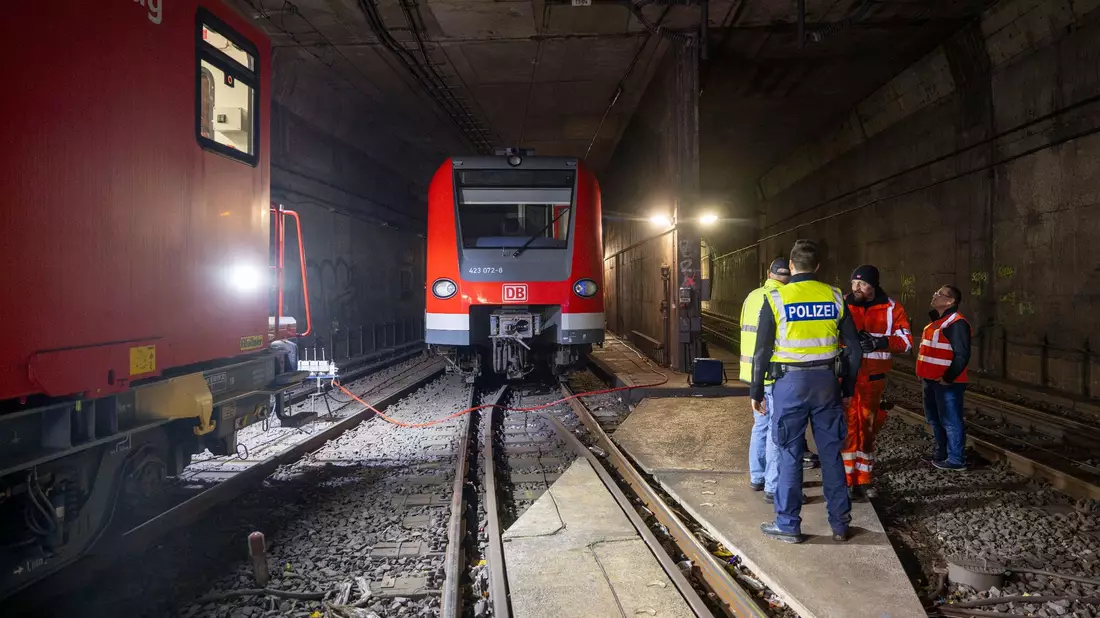 Bundespolizisten und Bahnarbeiter stehen in den Morgenstunden an der entgleisten S-Bahn im Tunnel hinter der Haltestelle Isartor. - Bild: Peter Kneffel/dpa
