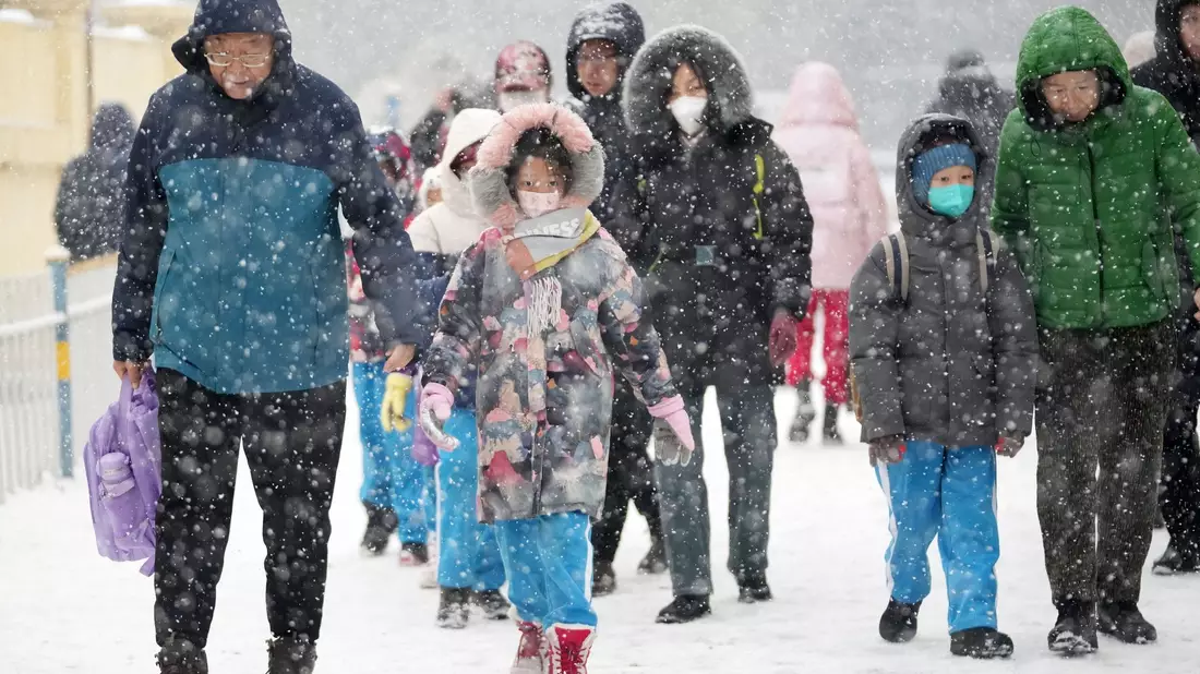 Eltern bringen ihre Kinder in Harbin zur Schule. - Bild: Wang Jianwei/XinHua/dpa
