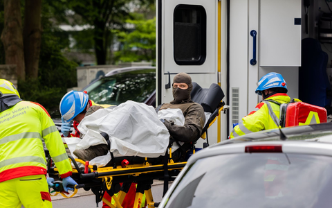 Ein verletzter Polizeibeamter wird vor einem Hochhaus in einen Krankenwagen gebracht. - Foto: Rolf Vennenbernd/dpa Ein verletzter Polizeibeamter wird vor einem Hochhaus in einen Krankenwagen gebracht. - Foto: Rolf Vennenbernd/dpa