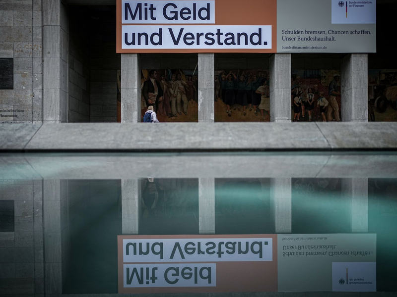 Ein Plakat mit der Aufschrift «Mit Geld und Verstand. Schulden bremsen, Chancen schaffen. Unser Bundeshaushalt» hängt über dem Eingang zum Bundesministerium der Finanzen in Berlin. - Foto: Kay Nietfeld/dpa