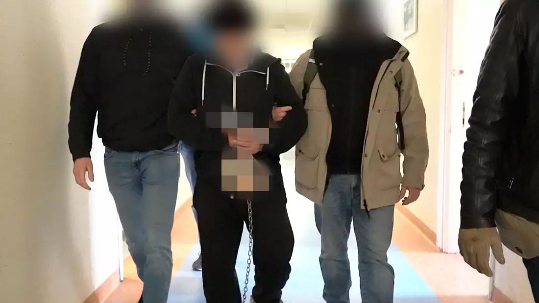Polizisten bringen den mutmaßlichen Doppelmörder (M) zur Vernehmung bei der Bezirksstaatsanwaltschaft Warschau. - Bild: Warschauer Polizeikommandantur/Warschauer Bezirksanwaltschaft/dpa
