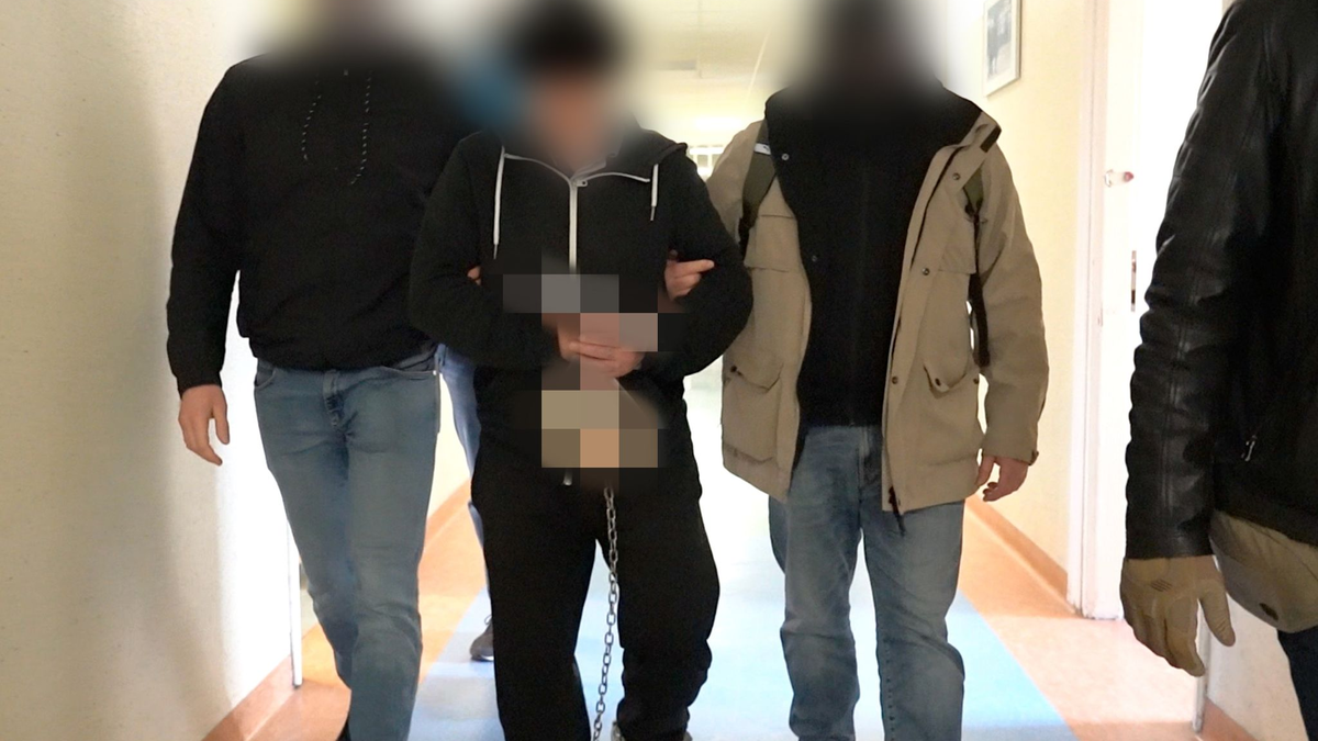 Polizisten bringen den mutmaßlichen Doppelmörder (M) zur Vernehmung bei der Bezirksstaatsanwaltschaft Warschau. - Foto: Warschauer Polizeikommandantur/Warschauer Bezirksanwaltschaft/dpa