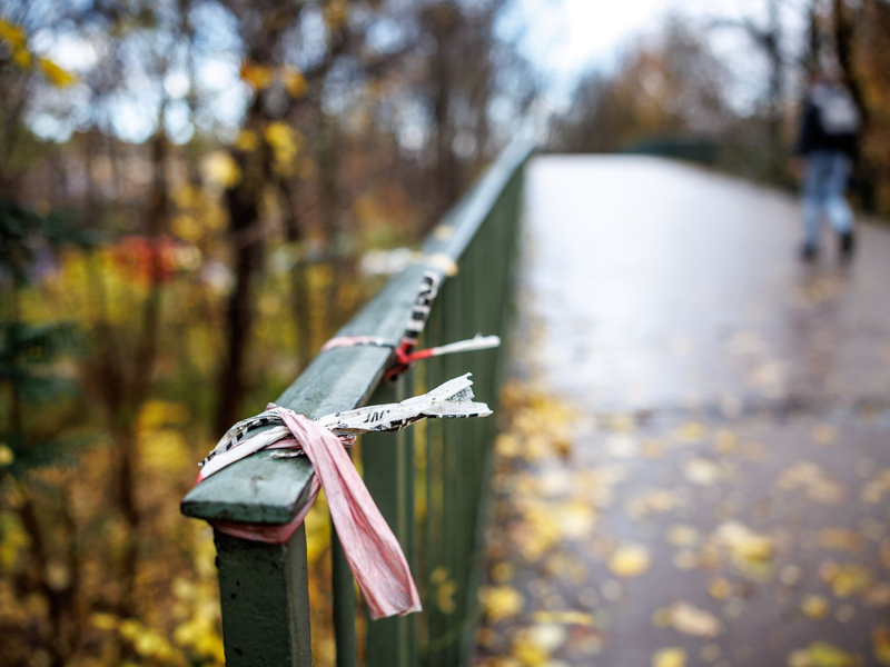 Der Rest eines Absperrbands der Polizei am  Geländer einer Fußgängerbrücke im Englischen Garten in München. Dort kam das Opfer zu Tode. - Foto: Matthias Balk/dpa