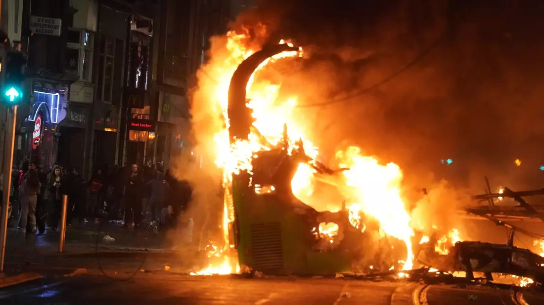 Ein Bus steht im Stadtzentrum in Flammen. - Bild: Brian Lawless/PA Wire/dpa