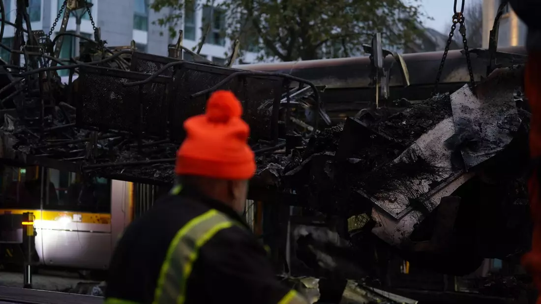 Spuren der Ausschreitungen in Dublin. Ein Arbeiter steht vor einer ausgebrannten Straßenbahn. - Bild: Brian Lawless/PA Wire/dpa
