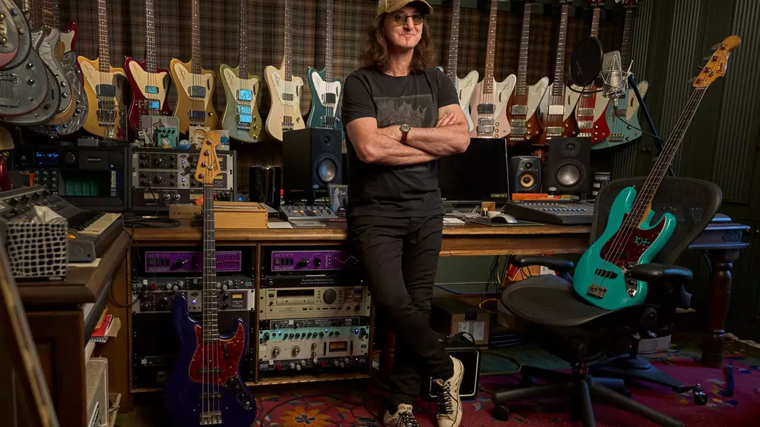 Der Rush-Frontmann Geddy Lee steht in seinem Studio, Bassgitarren hängen an der Wand. - Bild: HarperCollins
