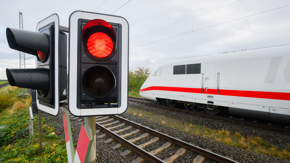 Eine rote Ampel leuchtet an einem Bahnübergang. Der Bahnverkehr auf der ICE-Strecke zwischen Köln und Frankfurt ist für eine Woche eingestellt. - Foto: Julian Stratenschulte/dpa
