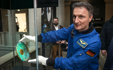 Der Astronaut Matthias Maurer platziert die Nachbildung der Himmelsscheibe von Nebra in einer Vitrine im Landesmuseum für Vorgeschichte Halle. - Foto: Heiko Rebsch/dpa Der Astronaut Matthias Maurer platziert die Nachbildung der Himmelsscheibe von Nebra in einer Vitrine im Landesmuseum für Vorgeschichte Halle. - Foto: Heiko Rebsch/dpa