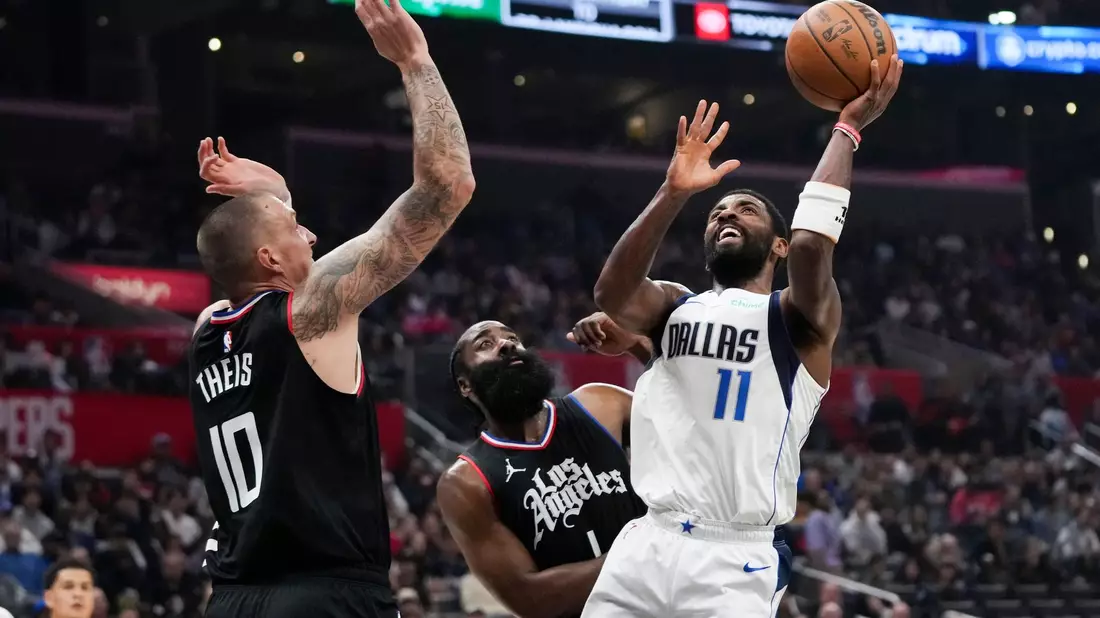 Kyrie Irving (r) von den Dallas Mavericks wirft unter dem Druck von James Harden (M) und Daniel Theis von den Los Angeles Clippers. - Bild: Jae C. Hong/AP/dpa