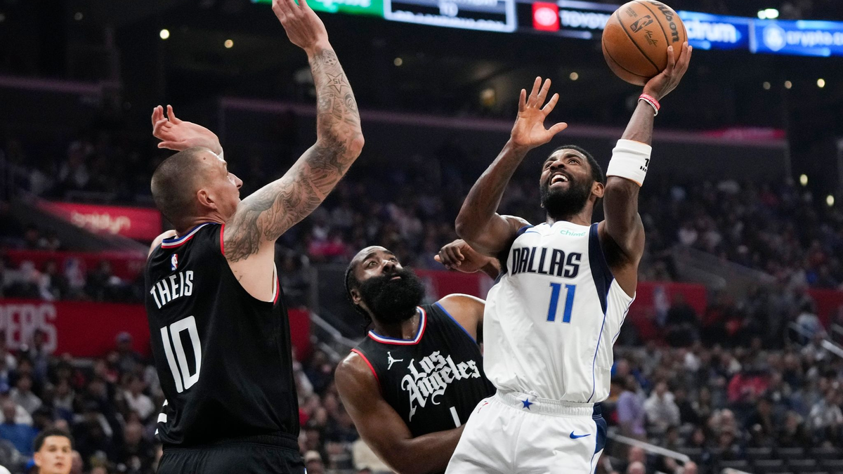 Kyrie Irving (r) von den Dallas Mavericks wirft unter dem Druck von James Harden (M) und Daniel Theis von den Los Angeles Clippers. - Foto: Jae C. Hong/AP/dpa