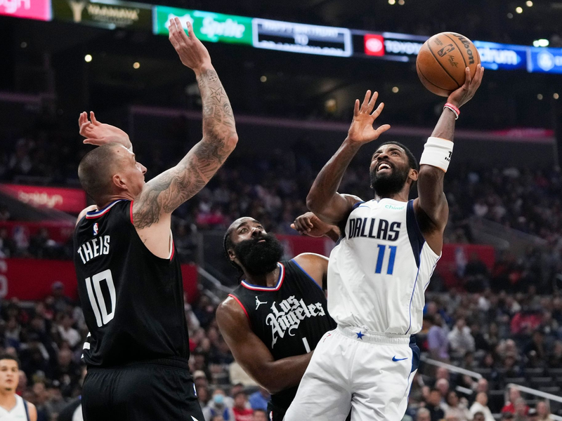 Kyrie Irving (r) von den Dallas Mavericks wirft unter dem Druck von James Harden (M) und Daniel Theis von den Los Angeles Clippers. - Foto: Jae C. Hong/AP/dpa