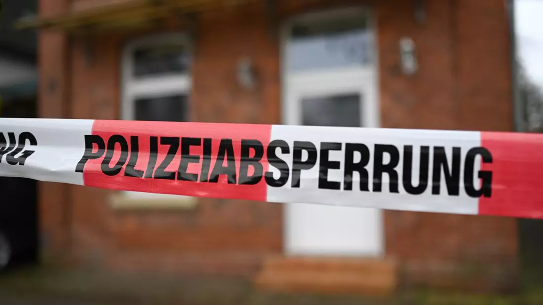 Der mit Flatterband abgesperrte Tatort: Eine Frau ist in der Nacht von Samstag auf Sonntag in Weener ermordet worden. - Bild: Lars Penning/dpa