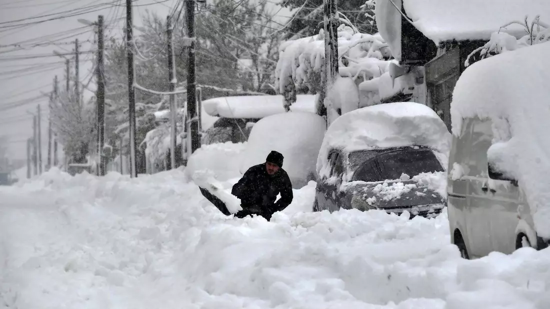 Ein Mann in Isperich schaufelt Schnee, um sein Auto zu befreien. - Bild: Mehmed Aziz/AP/dpa