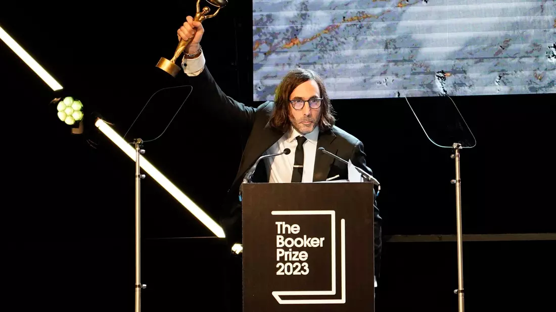 Paul Lynch, Gewinner des Booker Prize 2023, feiert kurz nach der Bekanntgabe auf der Bühne  in London. - Bild: Alberto Pezzali/AP/dpa
