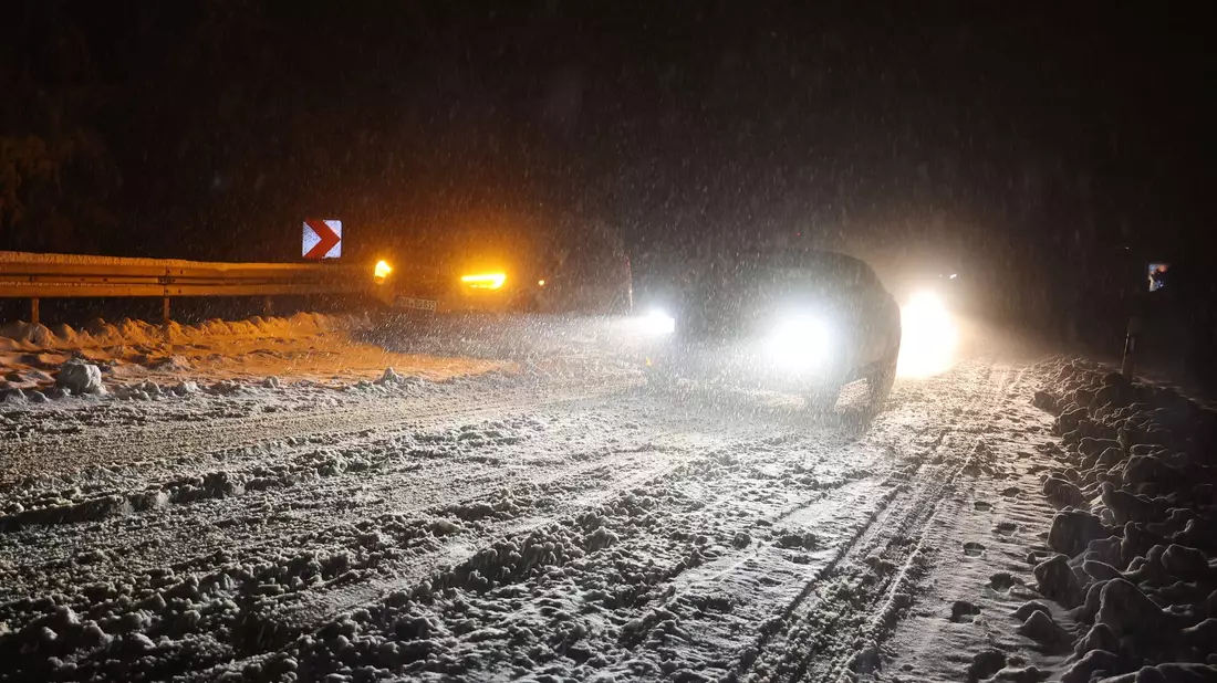 Autofahrer sind auf einer verschneiten Straße bei Niedernhausen (Hessen) unterwegs. - Bild: Jörg Halisch/dpa