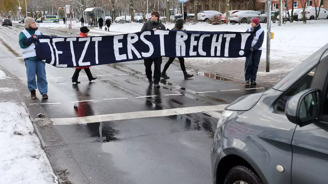 Mitglieder der «Letzten Generation» blockieren während des Prozesses in Stralsund eine Straße. - Bild: Bernd Wüstneck/dpa
