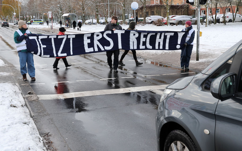 Mitglieder der «Letzten Generation» blockieren während des Prozesses in Stralsund eine Straße. - Foto: Bernd Wüstneck/dpa