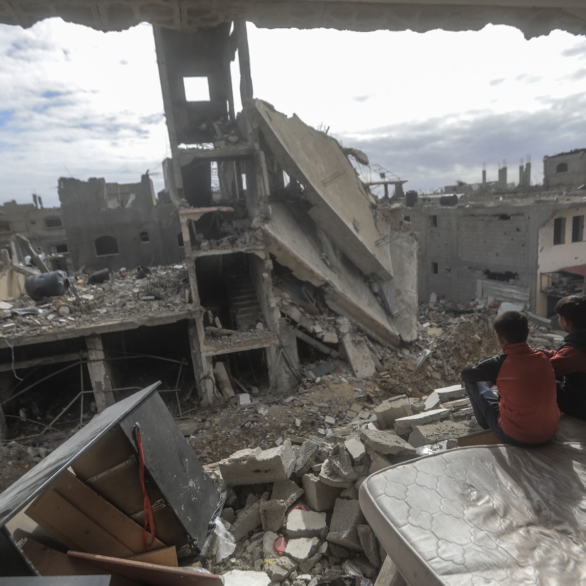 Palästinensische Kinder sitzen in einem zerstörten Haus im Dorf  Khuza'a nahe dem Grenzzaun zwischen Israel und dem südlichen Gazastreifen. - Foto: Mohammed Talatene/dpa