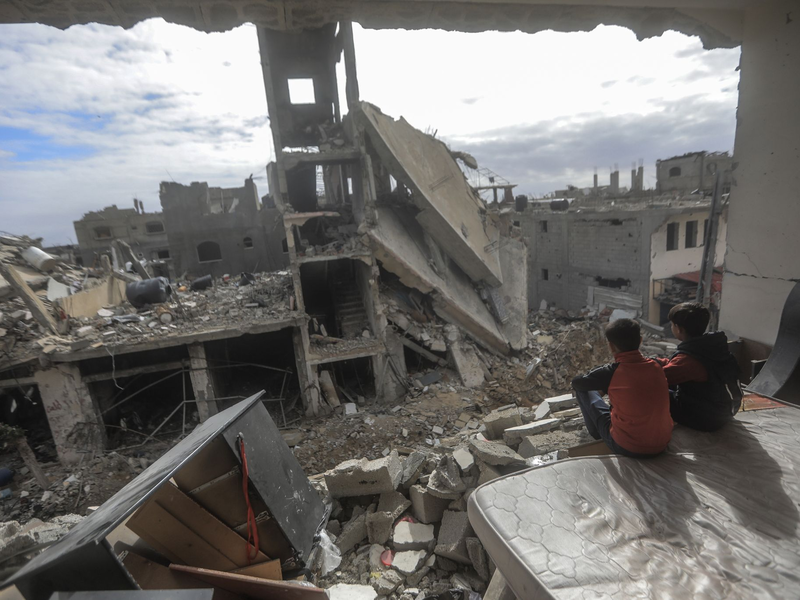 Palästinensische Kinder sitzen in einem zerstörten Haus im Dorf  Khuza'a nahe dem Grenzzaun zwischen Israel und dem südlichen Gazastreifen. - Foto: Mohammed Talatene/dpa