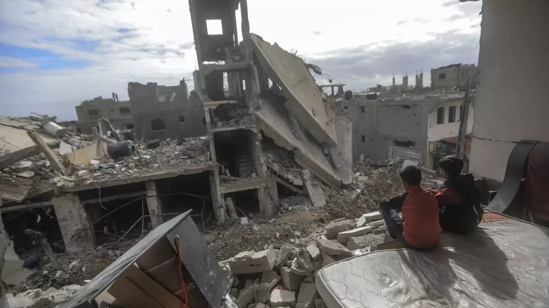 Palästinensische Kinder sitzen in einem zerstörten Haus im Dorf  Khuza'a nahe dem Grenzzaun zwischen Israel und dem südlichen Gazastreifen. - Bild: Mohammed Talatene/dpa