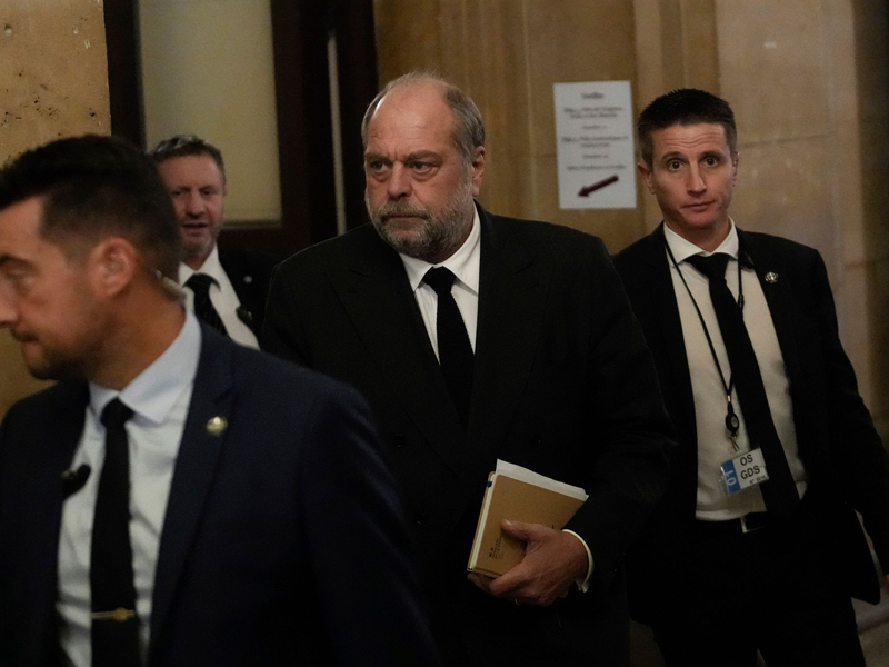 Der französische Justizminister Éric Dupond-Moretti (M) trifft im Gericht ein. Der Minister muss sich wegen angeblicher Interessenkonflikte und Amtsmissbrauchs verantworten. - Foto: Christophe Ena/AP/dpa
