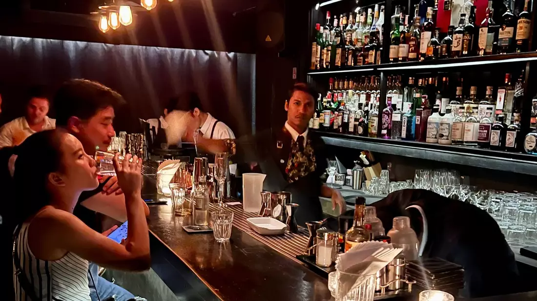 Gäste sitzen am Tresen einer Bar in Bangkok. - Bild: Carola Frentzen/dpa